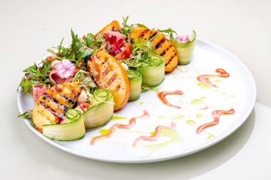 Fresh salad with ham and arugula, with grilled persimmon.