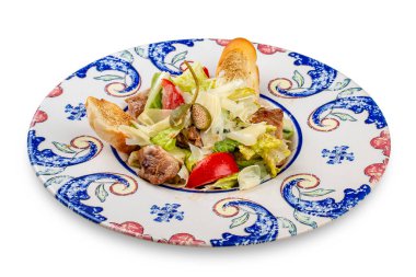 Fresh salad with baked duck and capers. In a decorative plate.