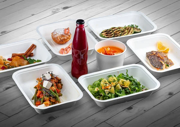 A set of healthy food dishes in ecological packaging on a wooden background. Food delivery. Takeaway.