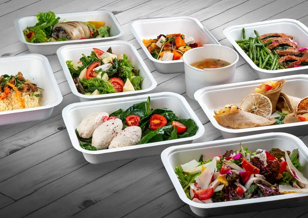 Ahşap bir arka planda ekolojik ambalajda bir dizi sağlıklı yiyecek. Yemek servisi. Paket servis.