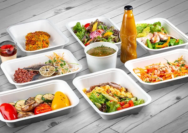 A set of healthy food dishes in ecological packaging on a wooden background. Food delivery. Takeaway.