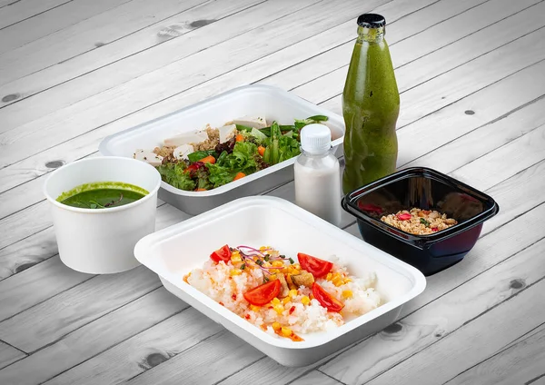 A set of healthy food dishes in ecological packaging on a wooden background. Food delivery. Takeaway.