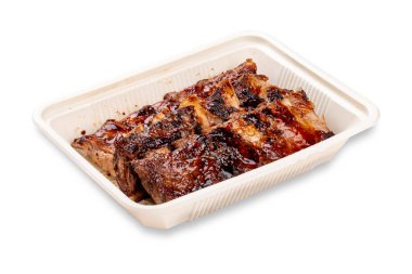 Izgara domuz pirzolası. Plastik bir kapta. Paket yemek. Hafif bir arkaplanda.