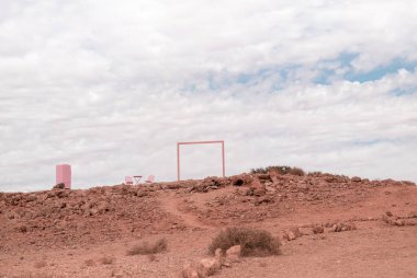 Pembe mobilyalar Namib çölünde bulutlu bir gökyüzünün arka planında duruyor. Namibya