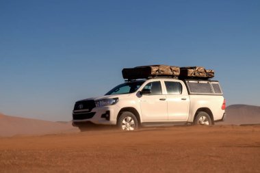 Kiralık araba - Toyota Hilux Namib çölünün altın kumlarında duruyor. Afrika 
