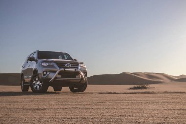 Toyota Fortuner, güneşli bir günde Namib Çölü 'nün ortasında duruyor. Namibya, Afrika 