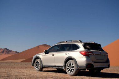 Gri Subaru, Namib çölünün kumlarında, parlak bir gökyüzünde. Walvis Körfezi, Namibya.