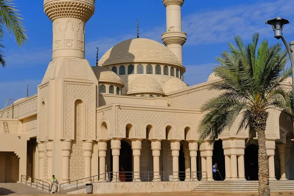 Domos adornados y minaretes de la mezquita islámica musulmana en Abu Dhabi, Emiratos Árabes Unidos sobre el fondo del cielo azul. Torre de minarete y cúpula de techo con elementos decorativos arquitectónicos árabes tradicionales de media luna. — Foto de Stock