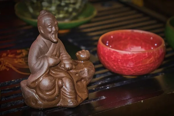 中国の古典的な茶文化に基本的な貢献をした前景に茶呂優の有名な古代のセージの陶器の図に焦点を当てて茶道を作るの断片。 — ストック写真
