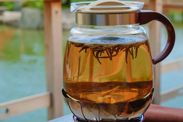 日本庭園での茶事の際に、透明ガラスの釜の中に湯沸かし湯に緑の茶葉を浮かべながら踊る。. — ストック写真