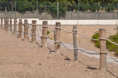 Doğada çitlerle çevrili yürüme yoluna odaklanın. Kamu arazisi koruma parkı. Çevresel ahşap direklerden ve bükülmüş halatlardan yapılmış..
