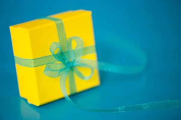 Yellow Gift Box on a Blue Background — Stock Photo, Image