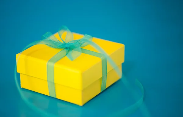 Yellow Gift Box on a Blue Background — Stock Photo, Image