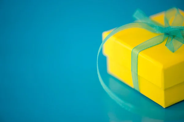 Yellow Gift Box on a Blue Background — Stock Photo, Image