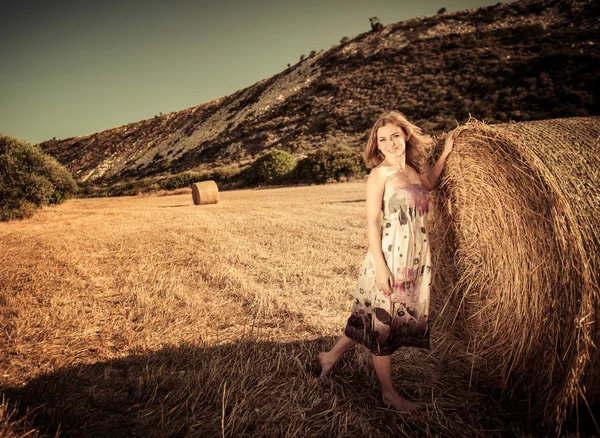 Young woman is walking on the harvest field — Stock Photo, Image