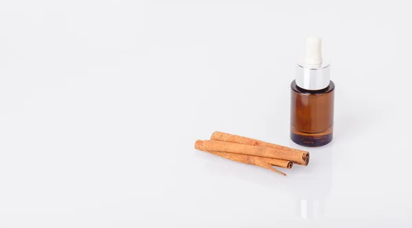 Aromatic oil and cinnamon sticks — Stock Photo, Image