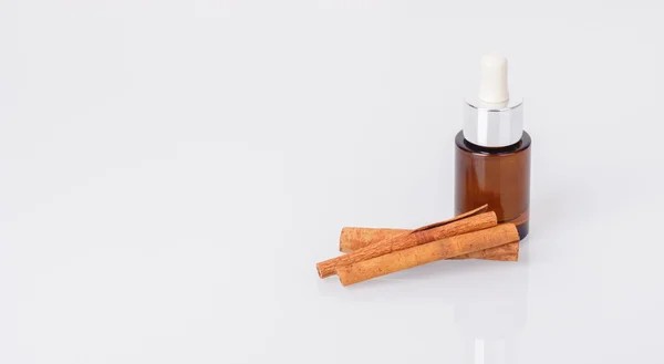 Aromatic oil and cinnamon sticks — Stock Photo, Image