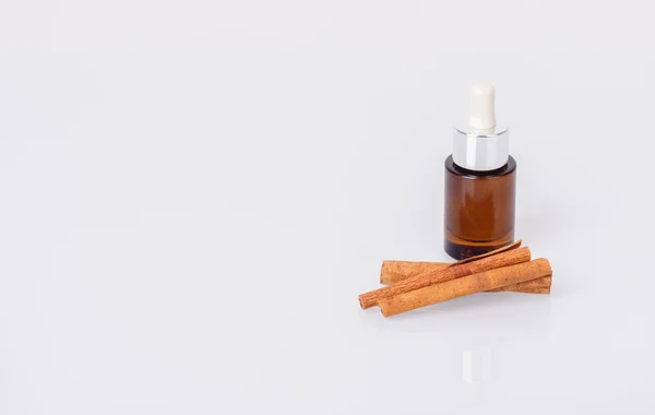 Aromatic oil and cinnamon sticks — Stock Photo, Image