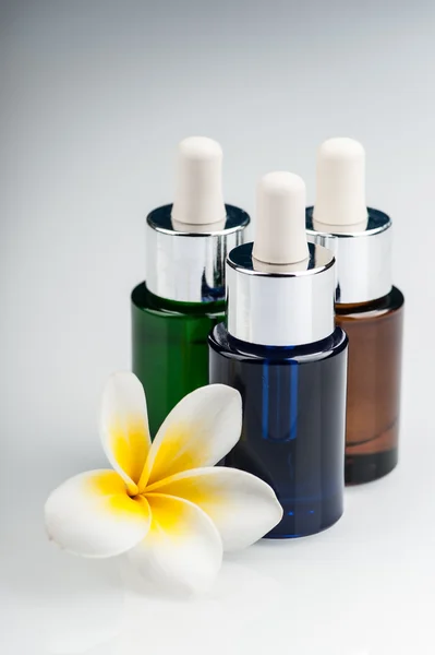 Spa theme - aromatic oils and a Plumeria flower — Stock Photo, Image