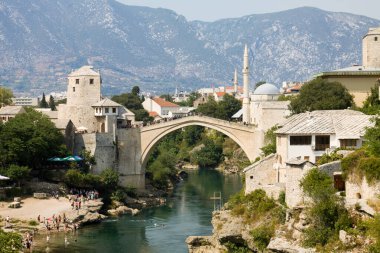 MOSTAR, BOSNIA VE HERZEGOVINA - 25 AĞUSTOS 2012: Neretva Nehri ve Eski Köprü ile Mostar şehir manzarası. Osmanlılar tarafından 16. yüzyılda inşa edilen Eski Köprü, Bosna-Hersek 'in başlıca simgelerinden biri..