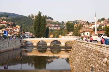 SARAJEVO, BOSNIA VE HERZEGOVINA - 25 Ağustos 2012: Miljacka nehri ve bir köprüsü olan Saraybosna şehir manzarası. Saraybosna Bosna-Hersek 'in başkenti. 