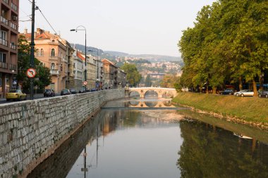 SARAJEVO, BOSNIA ve HERZEGOVINA - 25 Ağustos 2012: Miljacka nehri ve Latin köprüsü ile Saraybosna şehir manzarası. Saraybosna Bosna-Hersek 'in başkenti. 