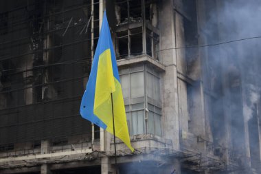 KIEV, UKRAINE - 19 Şubat 2014: Kiev Center. Ukrayna bayrağı, Sendika 'nın yanmış binasının arka planına karşı. 19 Şubat 201 'de Kiev' de bir sendika ayaklanmasının evi yakıldı.