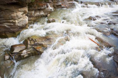 Dağlık bir nehirde fırtınalı bir su akıntısı.