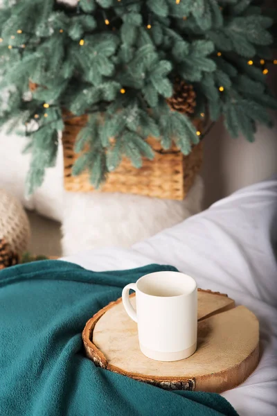 Noel sabahı kahvesi süslemeli bir Noel ağacının arka planında..