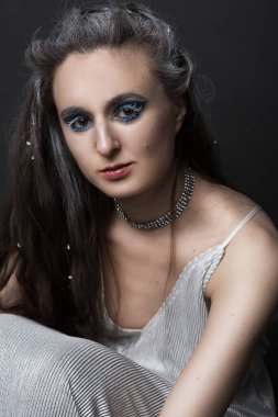 Kışın yaratıcı görüntüsüyle makyajlı üzgün güzel bir kadın. Kar Kraliçesi ya da siyah arka plandaki diğer üzgün karakterler..