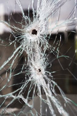 Broken glass with bullet holes.