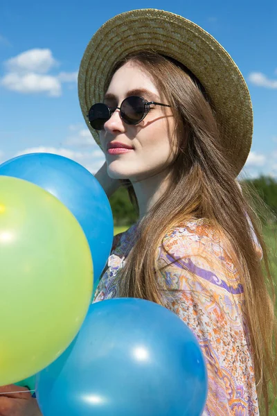 帽子の若い美しい女性の肖像画と空の背景に気球とサングラス — ストック写真