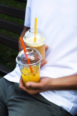 Genç adam elinde iki soğuk kokteyl tutuyor..