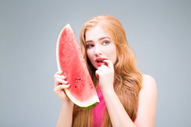 Funny young woman eating watermelon isolated on gray background. Healthy eating concept. Diet.