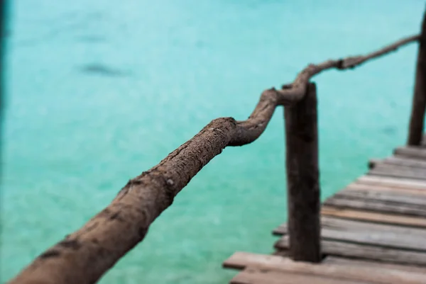 Blauwe transparante zee met houten bruggen — Stockfoto