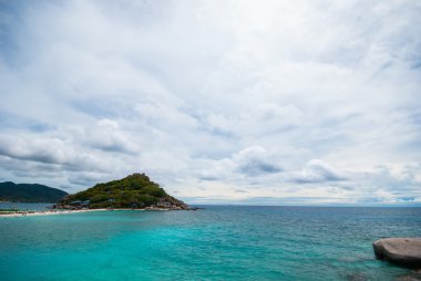 şeffaf mavi deniz, dağlar ve gökyüzü