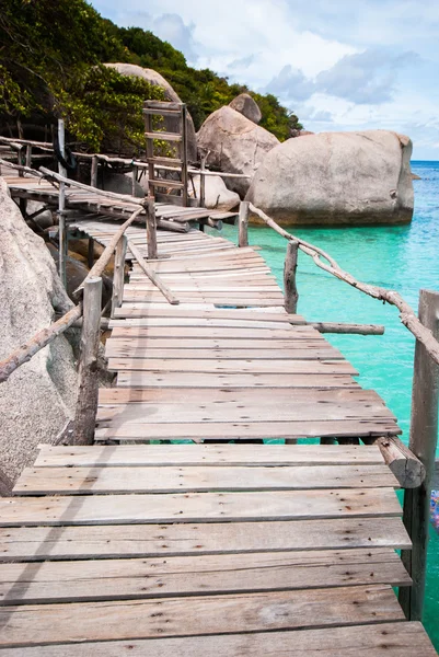 Blauwe transparante zee met houten bruggen — Stockfoto