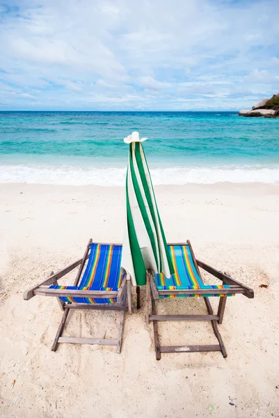 海滩椅子，沙滩上有雨伞 — 图库照片