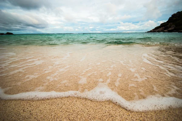 Vågen av havet på sandstranden — Stockfoto