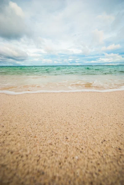 Vågen av havet på sandstranden — Stockfoto