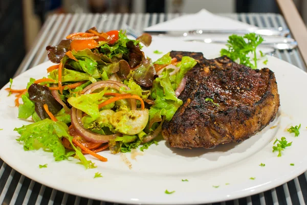 T-bone steak with salad. — Stock Photo, Image
