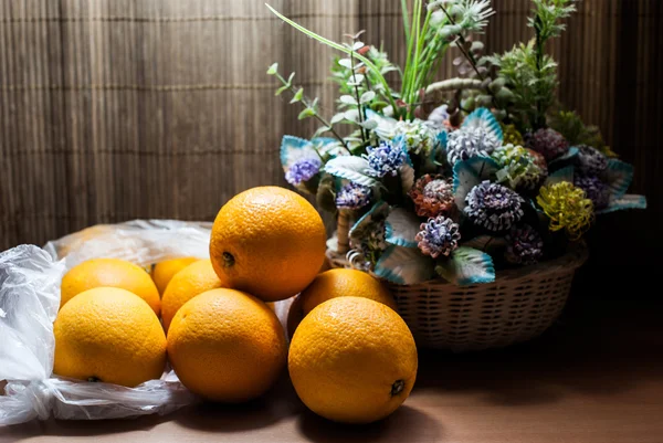 Belo buquê de flores e laranjas frescas — Fotografia de Stock
