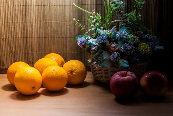 Mooie bloemboeket en verse sinaasappelen met appels — Stockfoto