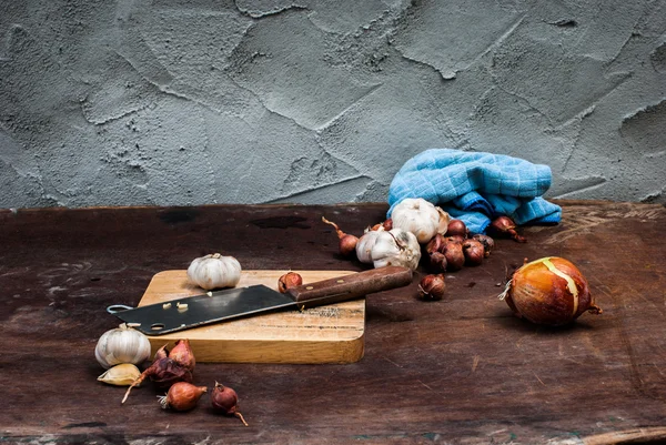 Шалот, лук, чеснок, рубленая доска и нож — стоковое фото