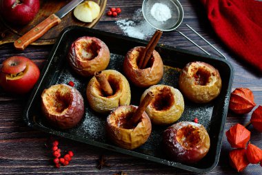 Tarçınlı fırınlanmış elmalar ve kırsal arka planda yakın plan fındıklar.