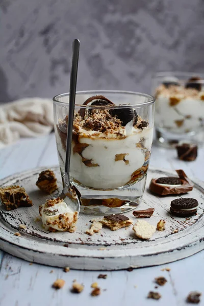 Dikey kompozisyon. Hafif arka planda çikolata parçalı lezzetli peynirli tatlı. Hafif, sağlıklı kahvaltı.