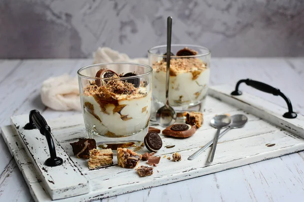 Gri masadaki tepside çikolata parçacıklı leziz peynir tatlısı. Hafif, sağlıklı atıştırmalıklar.