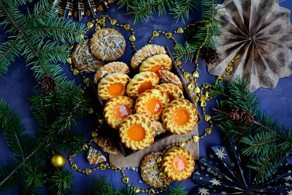 Appetizing cookies with jam filling and a pattern on the background of Christmas decor. Top view