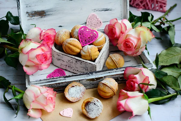 Composizione vintage per San Valentino. Biscotti appetitosi, rose rosa e cuori decorativi su uno sfondo rustico. — Foto Stock