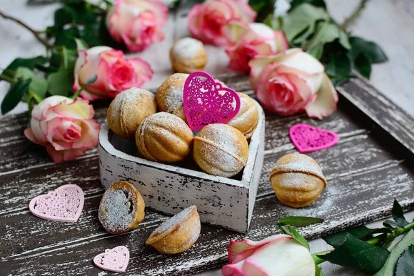 Composition alimentaire avec fleurs roses, biscuits et cœurs décoratifs sur un fond en bois. Gros plan. Saint Valentin et jours fériés — Photo